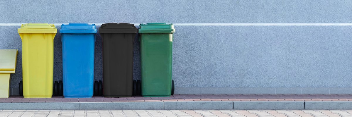 Ein Bild von Mülltonnen vor einer Hauswand