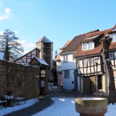 Es ist der Schlossplatz mit dem Hexenturm von Babenhausen im Winter zu sehen