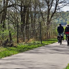 Man sieht zwei Menschen die auf einem Radweg fahren