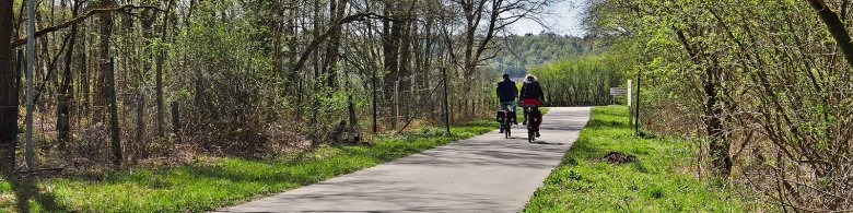 Man sieht zwei Menschen die auf einem Radweg fahren