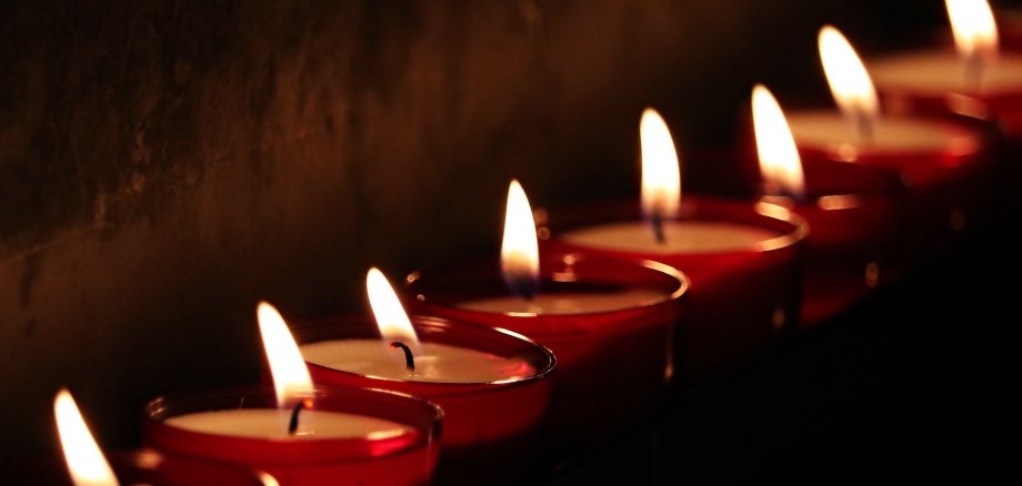 Auf dem Bild sieht man Kerzen, welche für Trauer stehen