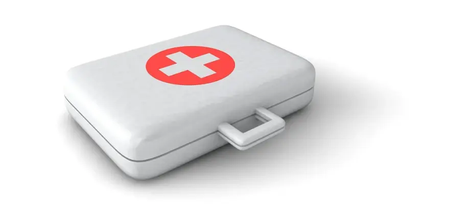 Weiße Erste-Hilfe-Box mit rotem Kreis und weißem Kreuz auf dem Deckel.