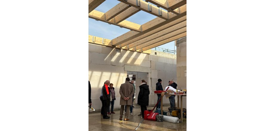 Personen stehen im Rohbau