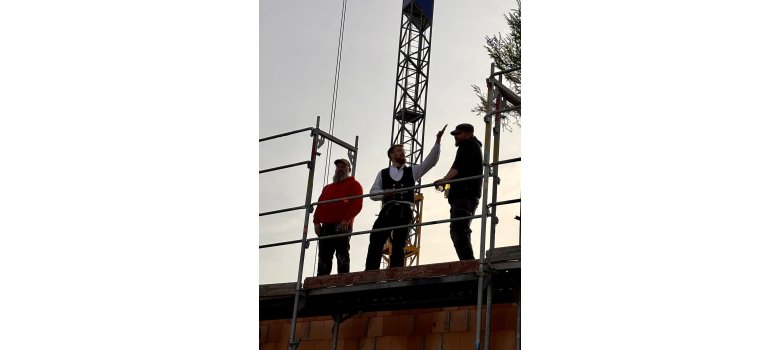 Personen stehen auf einem Gerüst