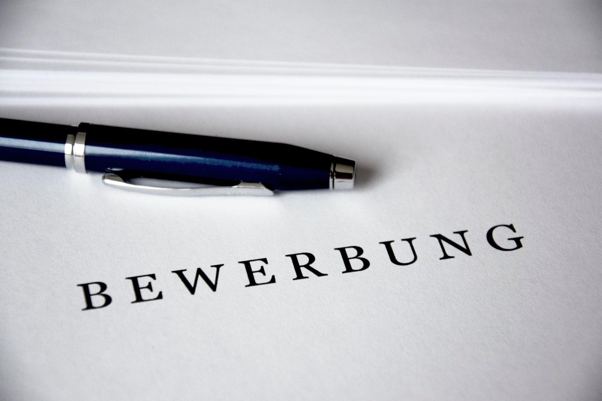 Blatt mit Wort "Bewerbung" und einem Stift