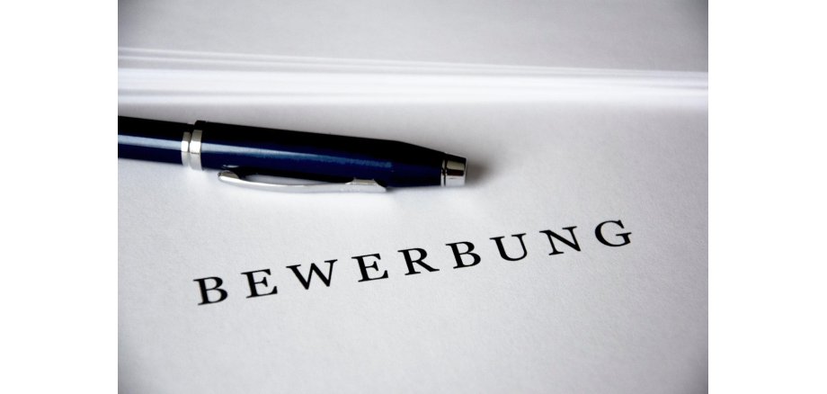 Blatt mit Wort "Bewerbung" und einem Stift