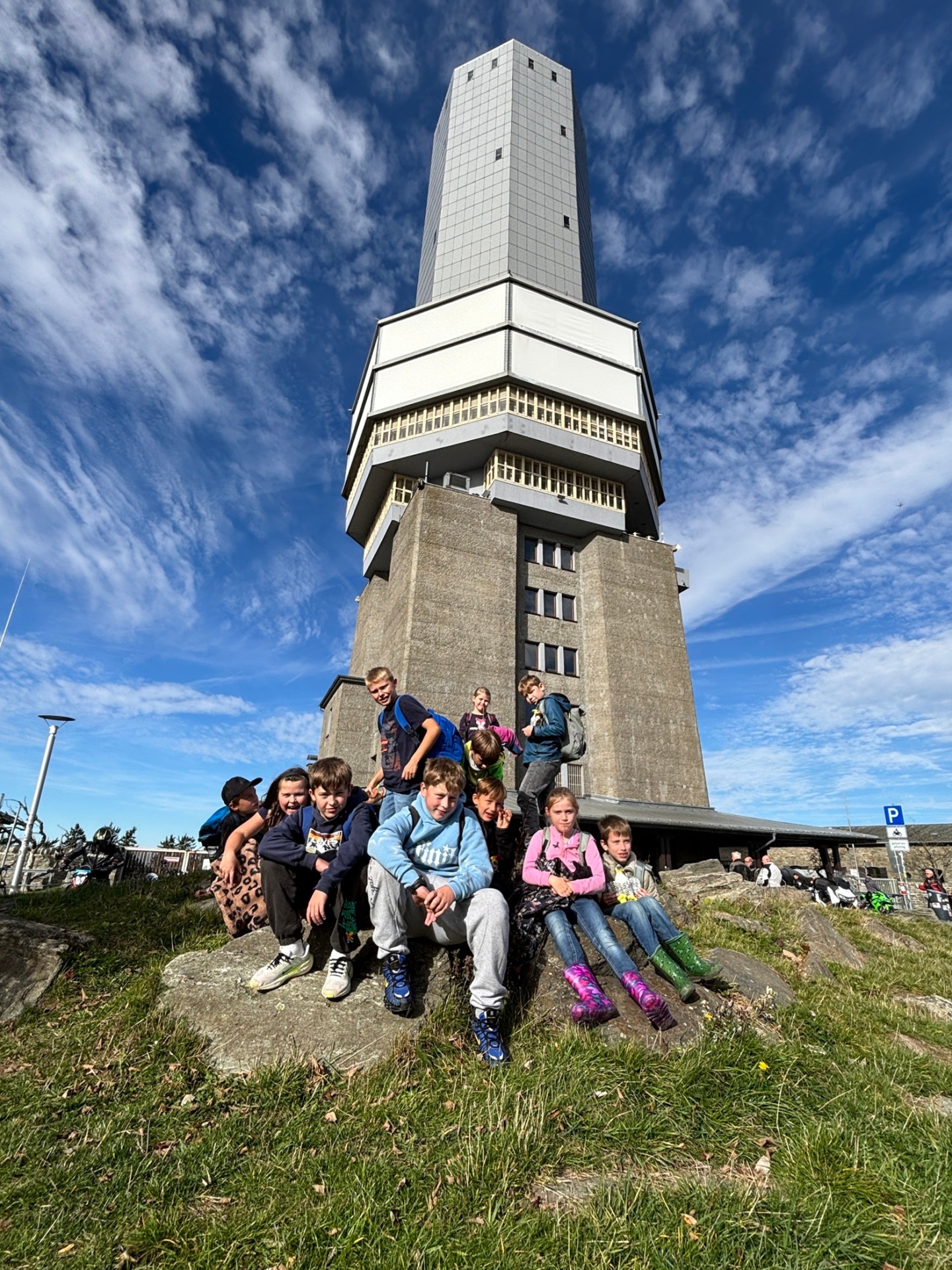 Gruppe sitzt vor Turm auf dem Feldberg