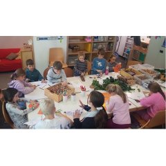 Kids sitzen am Tisch und basteln