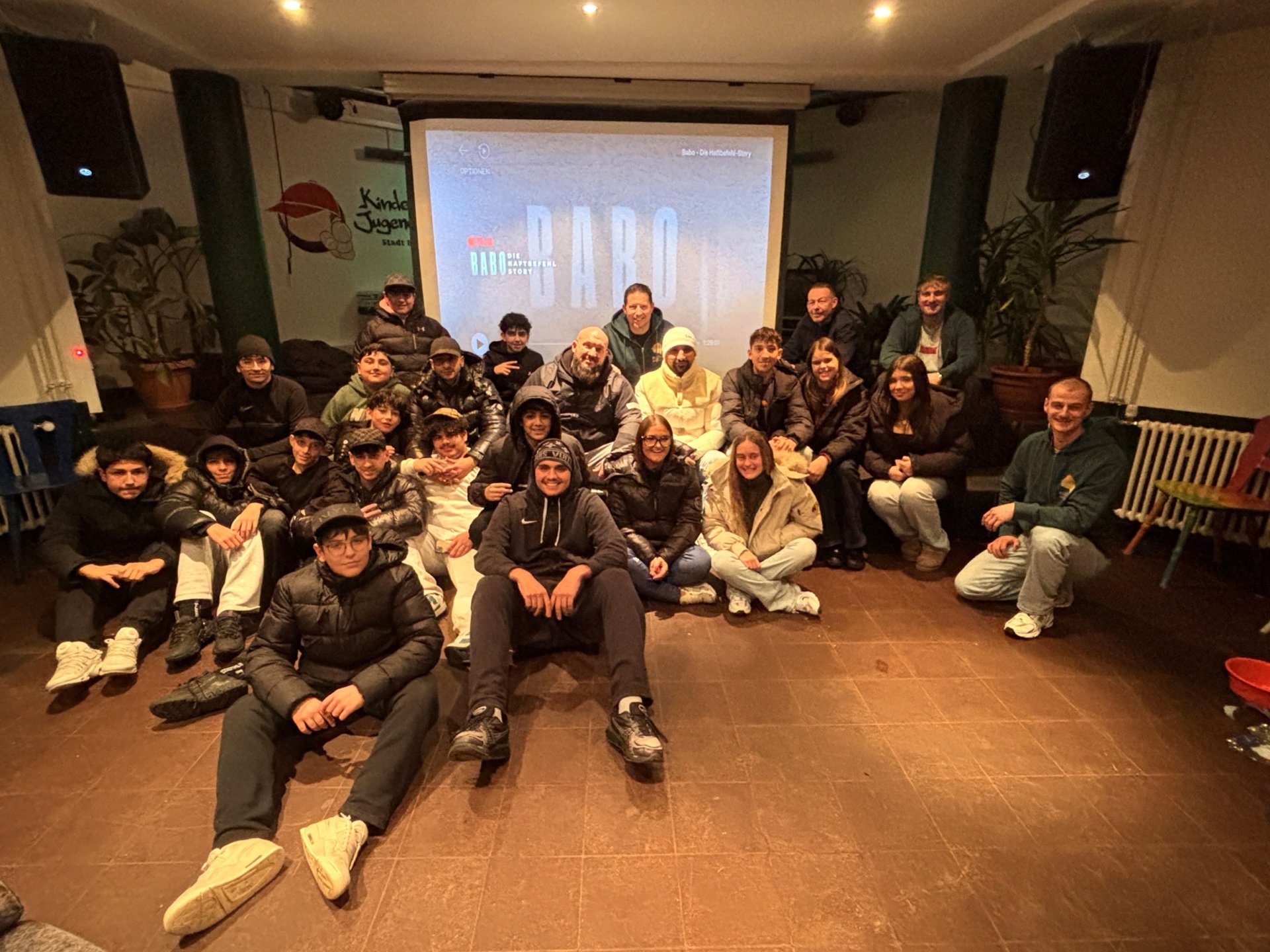 Gruppe Menschen sitzen vor Leinwand