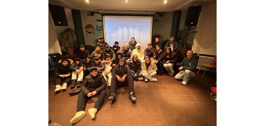 Gruppe Menschen sitzen vor Leinwand