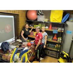 Personen stehen vor Geräteschrank in Halle