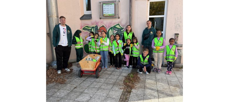 Kinder, die in grünen Westen ein Gruppenfoto mit den Betreuern machen