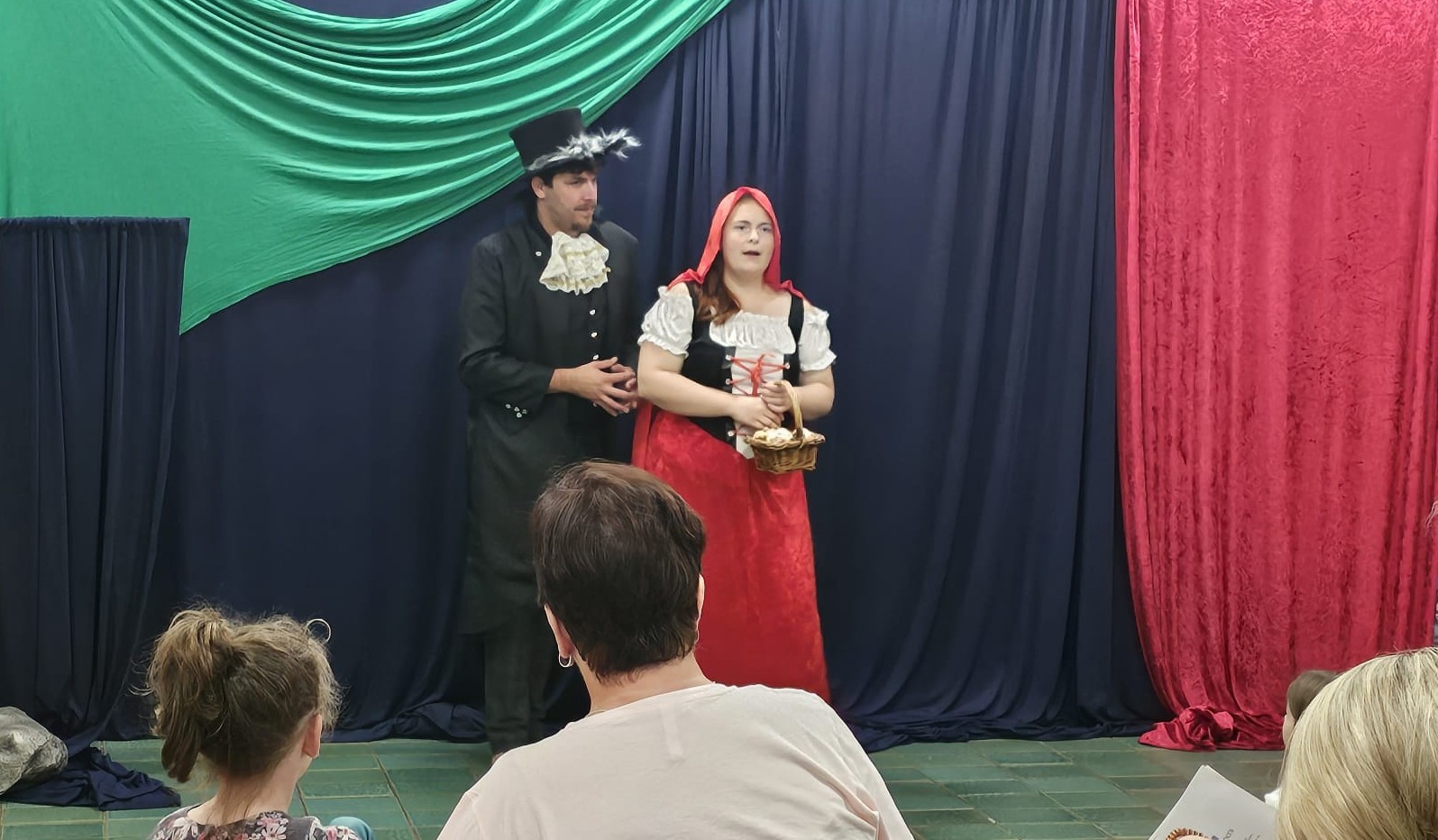 Zwei Personen auf einer Bühne, spielen "Rotkäppchen"