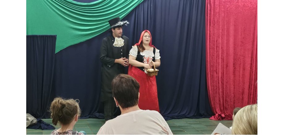 Zwei Personen auf einer Bühne, spielen "Rotkäppchen"