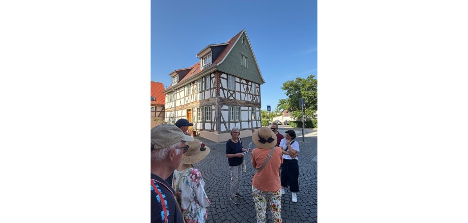 Personen stehen vor Fachwerkhaus