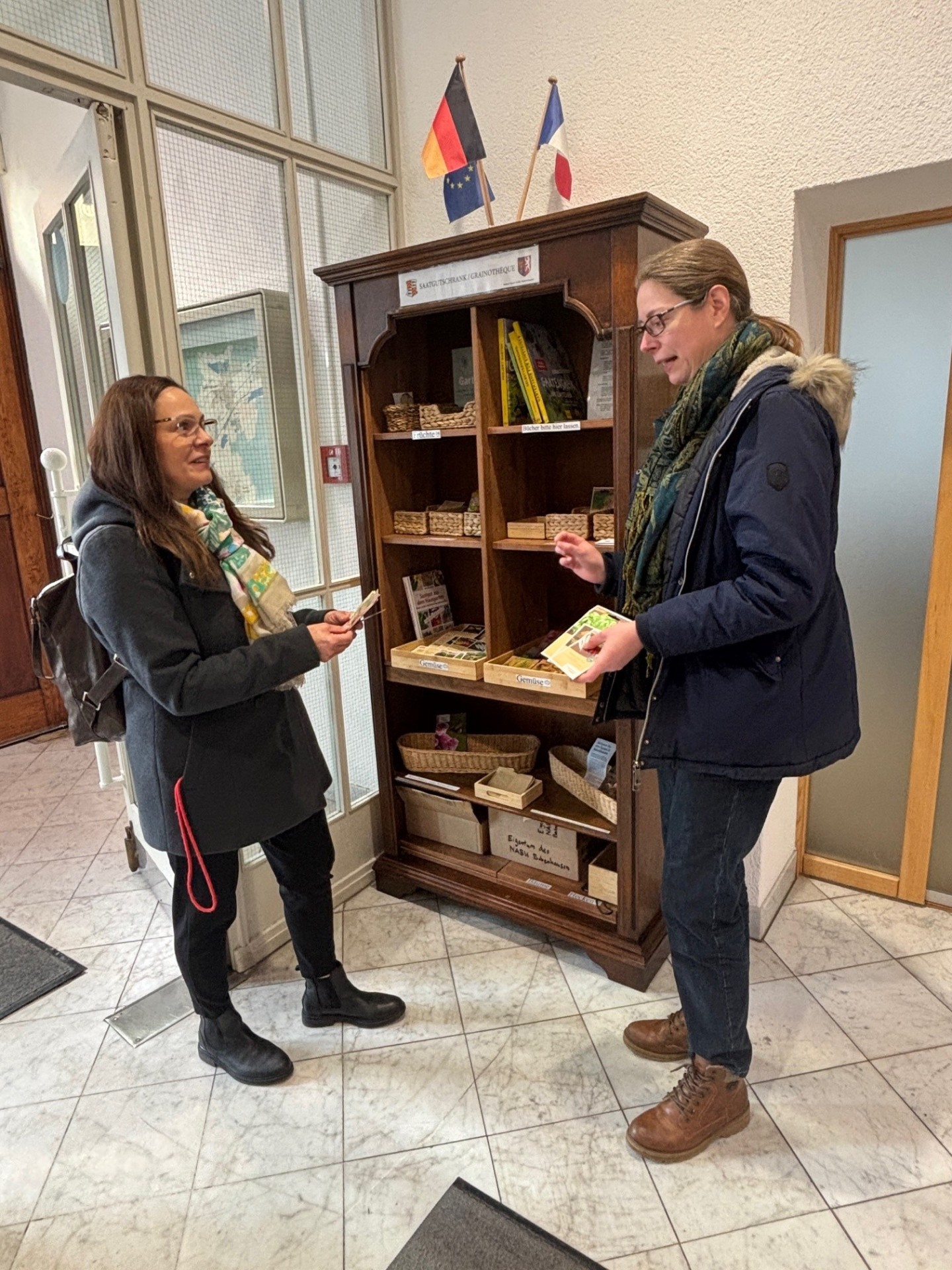 Ulrike Gencarelle vom NABU Babenhausen erklärt einer Besucherin des Rathauses die Funktion des Saatgutschrankes.