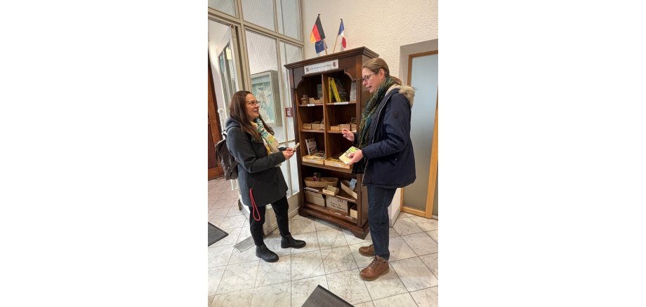 Ulrike Gencarelle vom NABU Babenhausen erklärt einer Besucherin des Rathauses die Funktion des Saatgutschrankes.