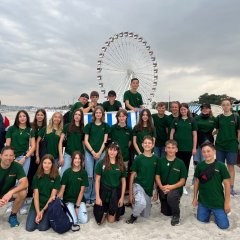 Gruppenfoto am Strand mit Riesenrad im Hintergrund