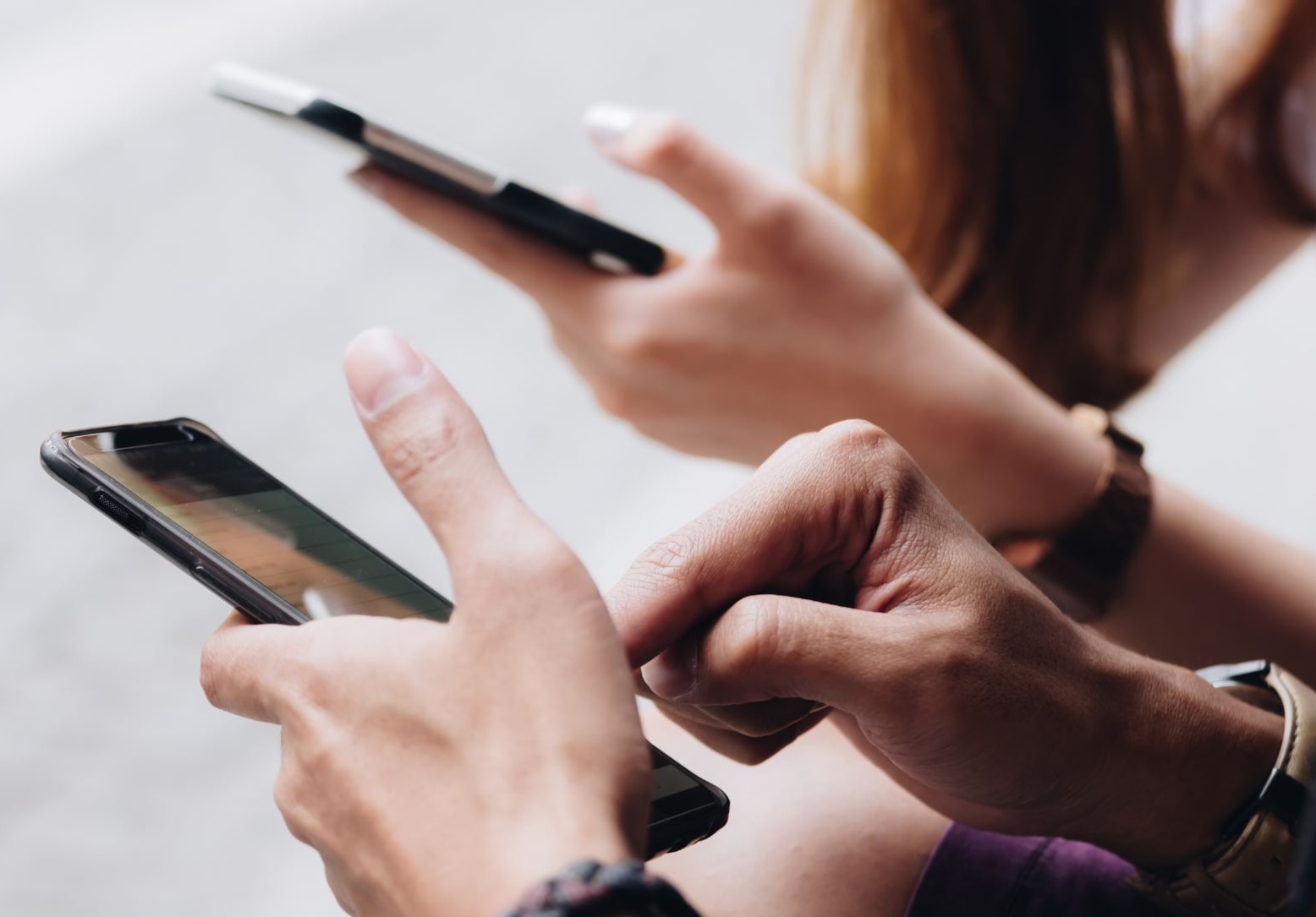 Zwei Personen nutzen ihre Smartphones.
