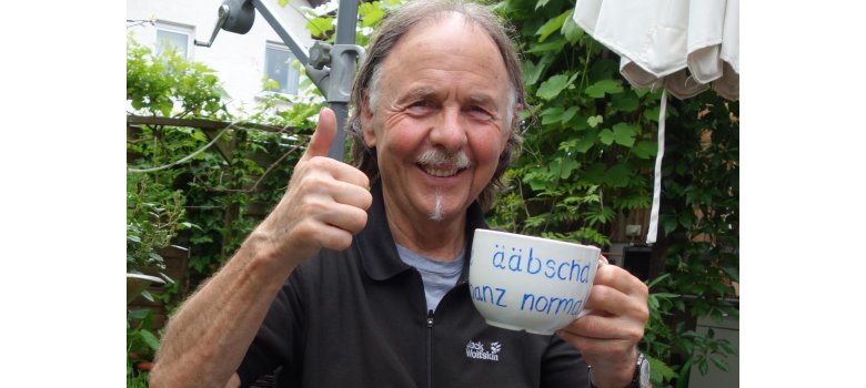 Rainer Weisbecker mit Daumen hoch und Tasse in der Hand