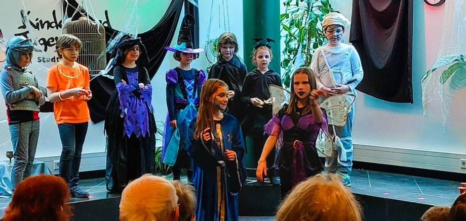 Man sieht Kinder die sich zu Halloween verkleidet haben.