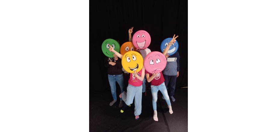 Kinder mit bunten Smilies vor dem Gesicht