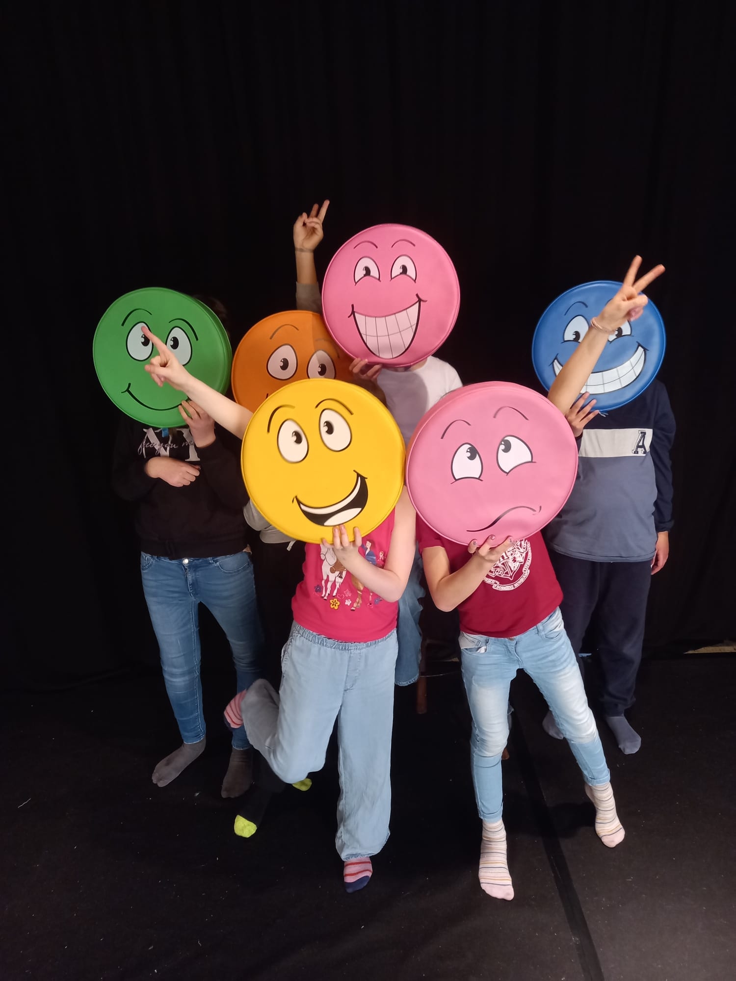 Kinder mit bunten Smilies vor dem Gesicht