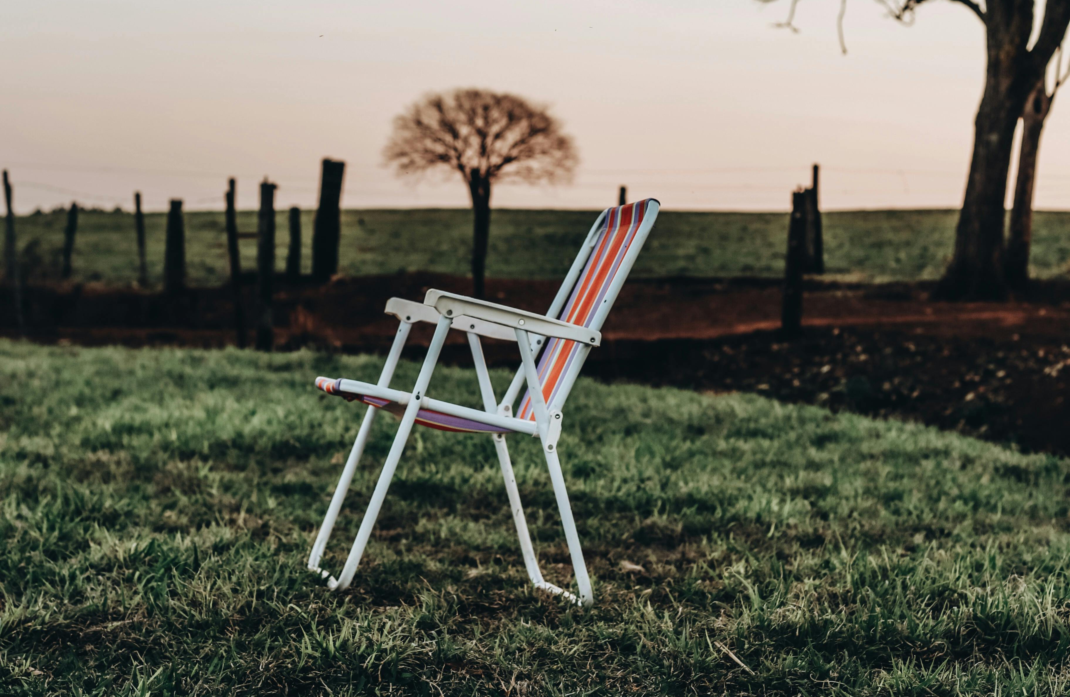 Ein Klappstuhl steht auf einer grünen Wiese