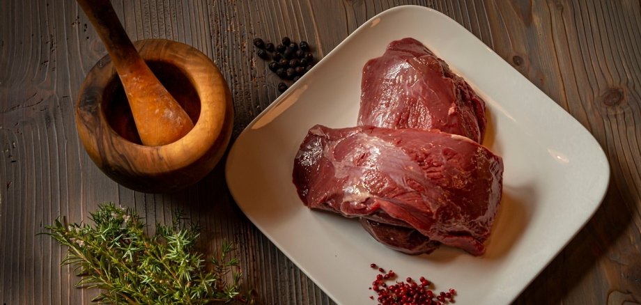 Auf dem Bild sieht man Hirschfleisch, dass zubereitet wird.