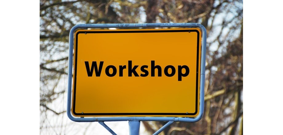 Man sieht ein Straßenschild mit der Aufschrift Workshop