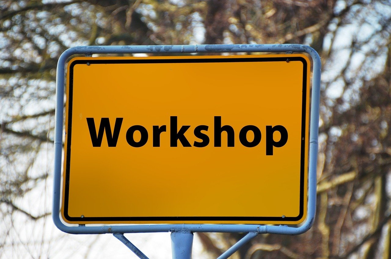 Man sieht ein Straßenschild mit der Aufschrift Workshop