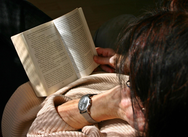Person liest ein Buch, von oben fotografiert