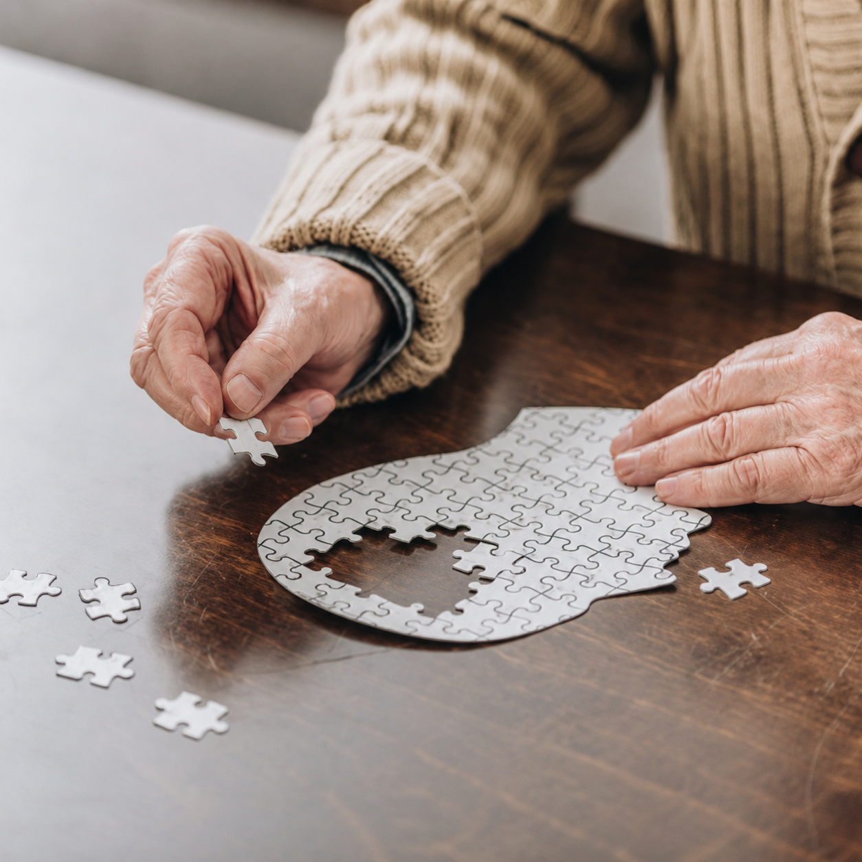 Alter Mensch puzzelt, man sieht nur die Hände