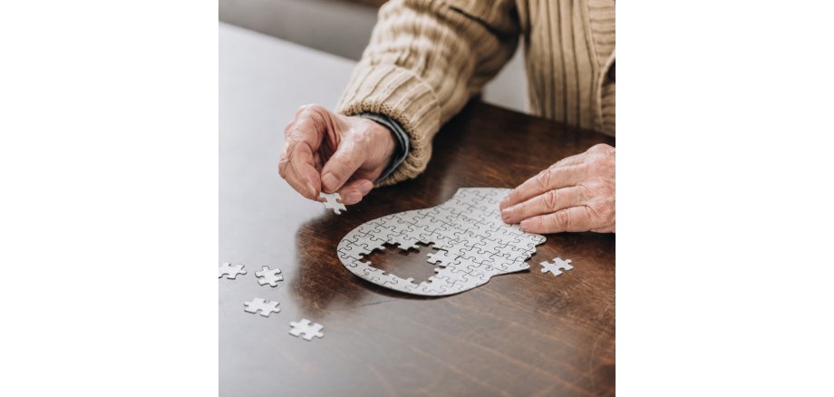 Alter Mensch puzzelt, man sieht nur die Hände