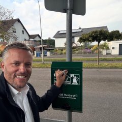 Auf dem Bild sieht man den Bürgermeister Dominik Stadler und ein Hunde WC.