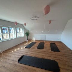 Man sieht einen Raum mit Sportmatten die auf dem Boden legen. Der Raum ist mit Luftballons an der Decke geschmückt.