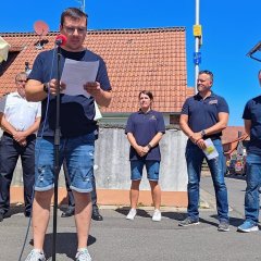 Man sieht den Bürgermeister Dominik Stadler und die Feuerwehr von Harpertshausen.