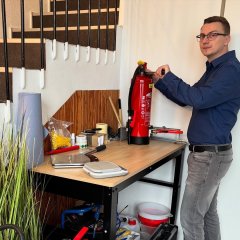 Man sieht einen Mann und einen Feuerlöscher