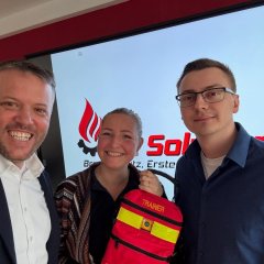 Man sieht den Bürgermeister Dominik Stadler, einen Mann und eine Frau mit einem Feuerlöscher in der Hand. 