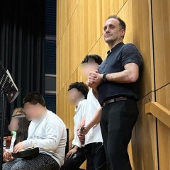 Man sieht einen Mann auf der Bühne.
