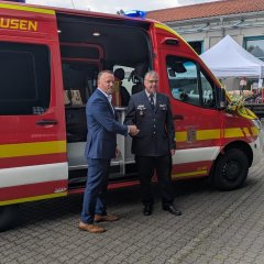 Auf dem Bild sieht man den Bürgermeister Dominik Stadler vor einem Feuerwehrauto.