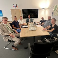 Auf dem Bild sieht man den Bürgermeister Dominik Stadler und weitere Menschen bei einer Besprechung in seinem Büro.
