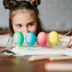Man sieht ein Kind und bunte Ostereier