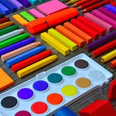 Man sieht geordnete bunte Kreide und ein bunter Malkasten.