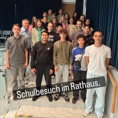 Auf dem Bild sieht man den Bürgermeister Dominik Stadler und eine Schulklasse die zu Besuch im Rathaus ist.