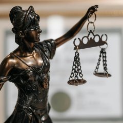 Figur mit Waage in der Hand