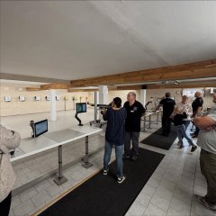 Auf dem Bild sieht man den Schützenverein und eine Frau mit einem Gewehr in der Hand.