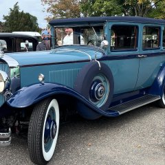 Auf dem Bild sieht man ein altes blaues Auto.