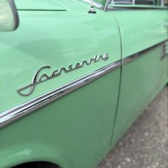 Auf dem Bild sieht man ein altes grünes Auto.