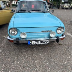 Auf dem Bild sieht man ein altes blaues Auto.